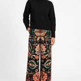 Model wearing Aveline Black Aubussy printed velvet wide-leg pants with a black sweater, front view