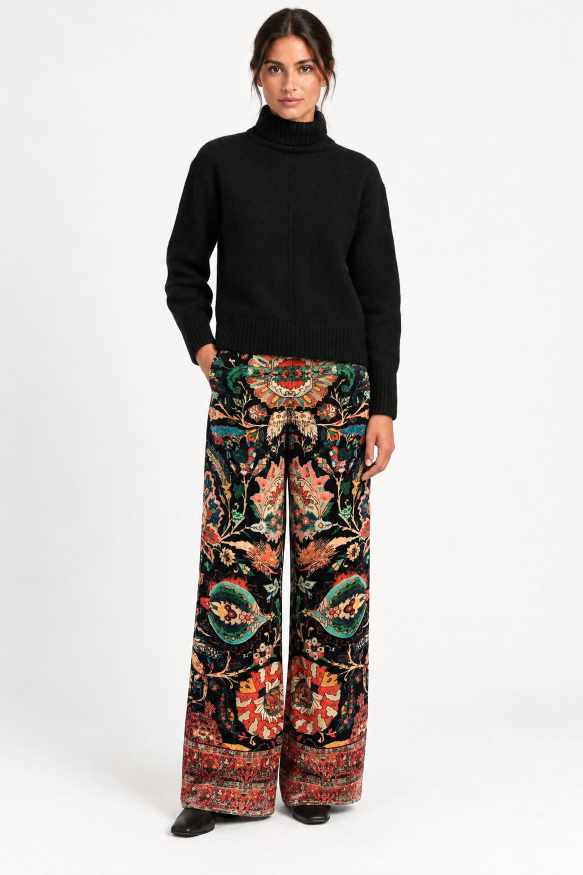 Model wearing Aveline Black Aubussy printed velvet wide-leg pants with a black sweater, front view