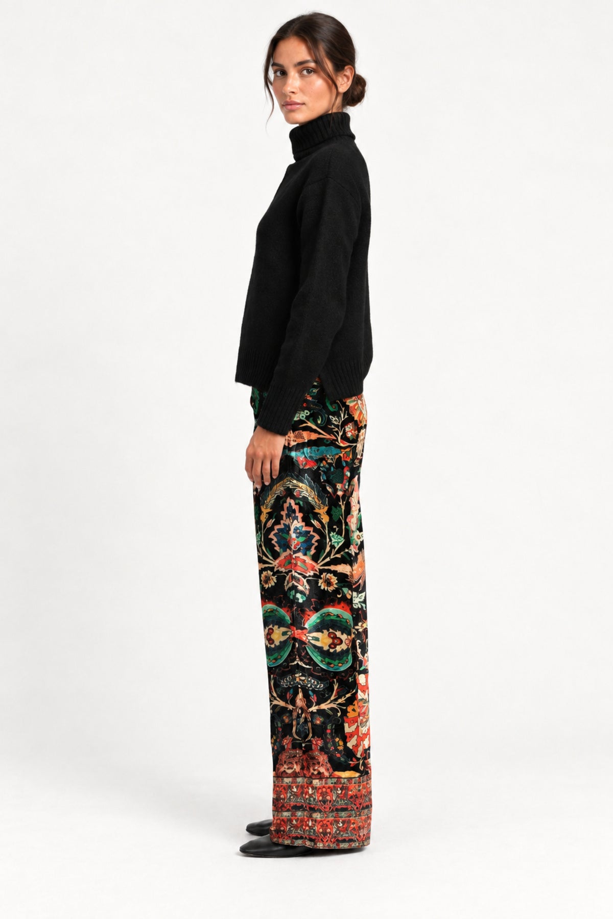 Side view of model wearing Aveline Black Aubussy pants with a black turtleneck