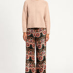 Model wearing Aveline Doriala Multi printed velvet wide-leg pants with a nude sweater, front view