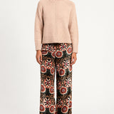 Model wearing Aveline Doriala Multi printed velvet wide-leg pants with a nude sweater, front view