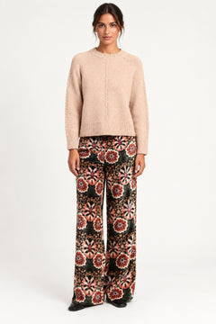 Model wearing Aveline Doriala Multi printed velvet wide-leg pants with a nude sweater, front view