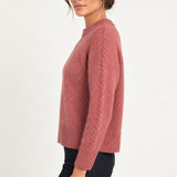 Clémence cable-detail crewneck sweater in Rosewood, side model view on an ivory backdrop