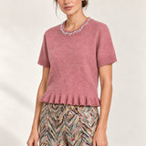 Three-quarter view of the Émeline Rose Jeweled Ruffle-Hem Sweater paired with Héloïse Multico Chevron pants