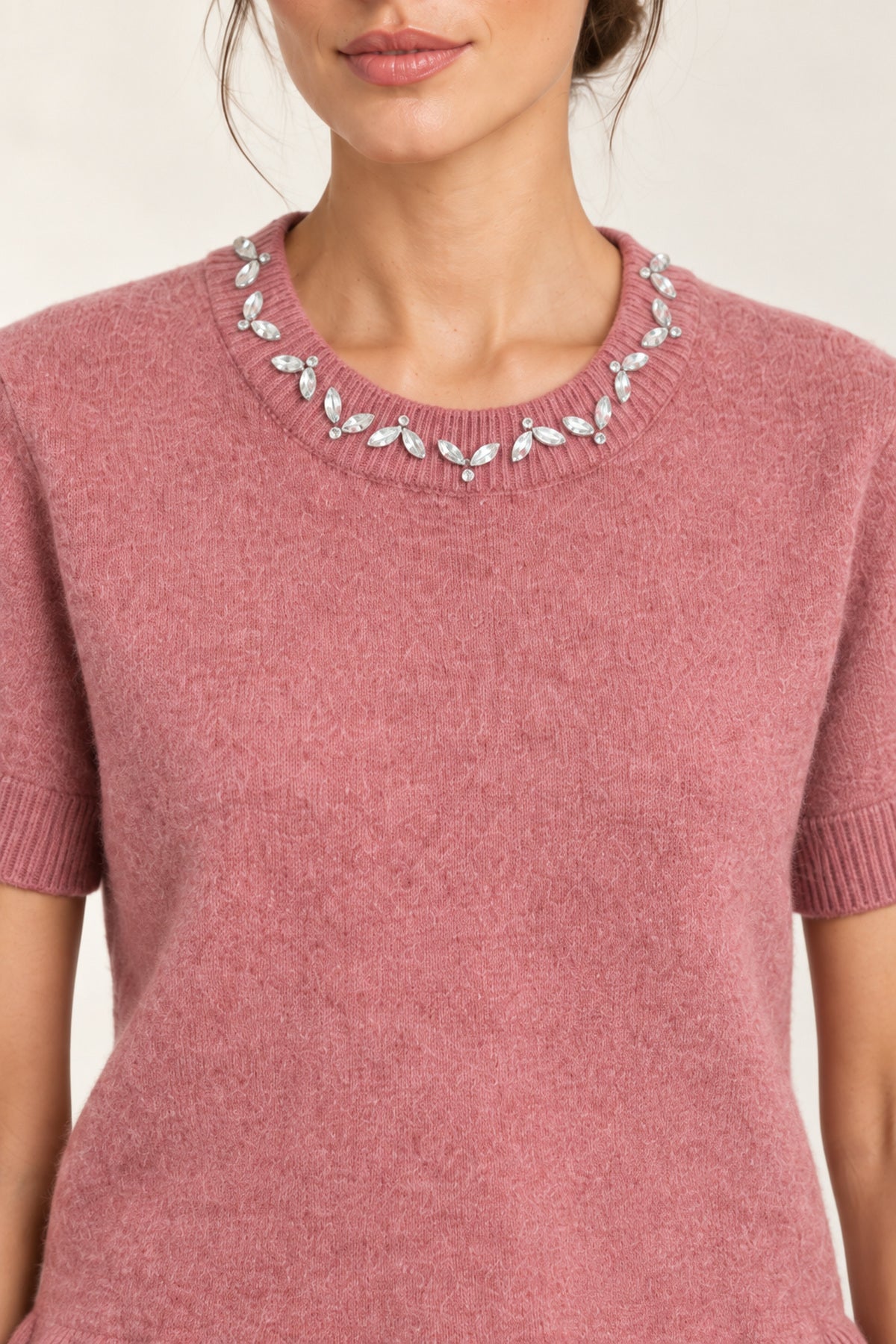 Close-up of the Émeline Rose sweater's jeweled crew neckline, short sleeve and soft knit texture