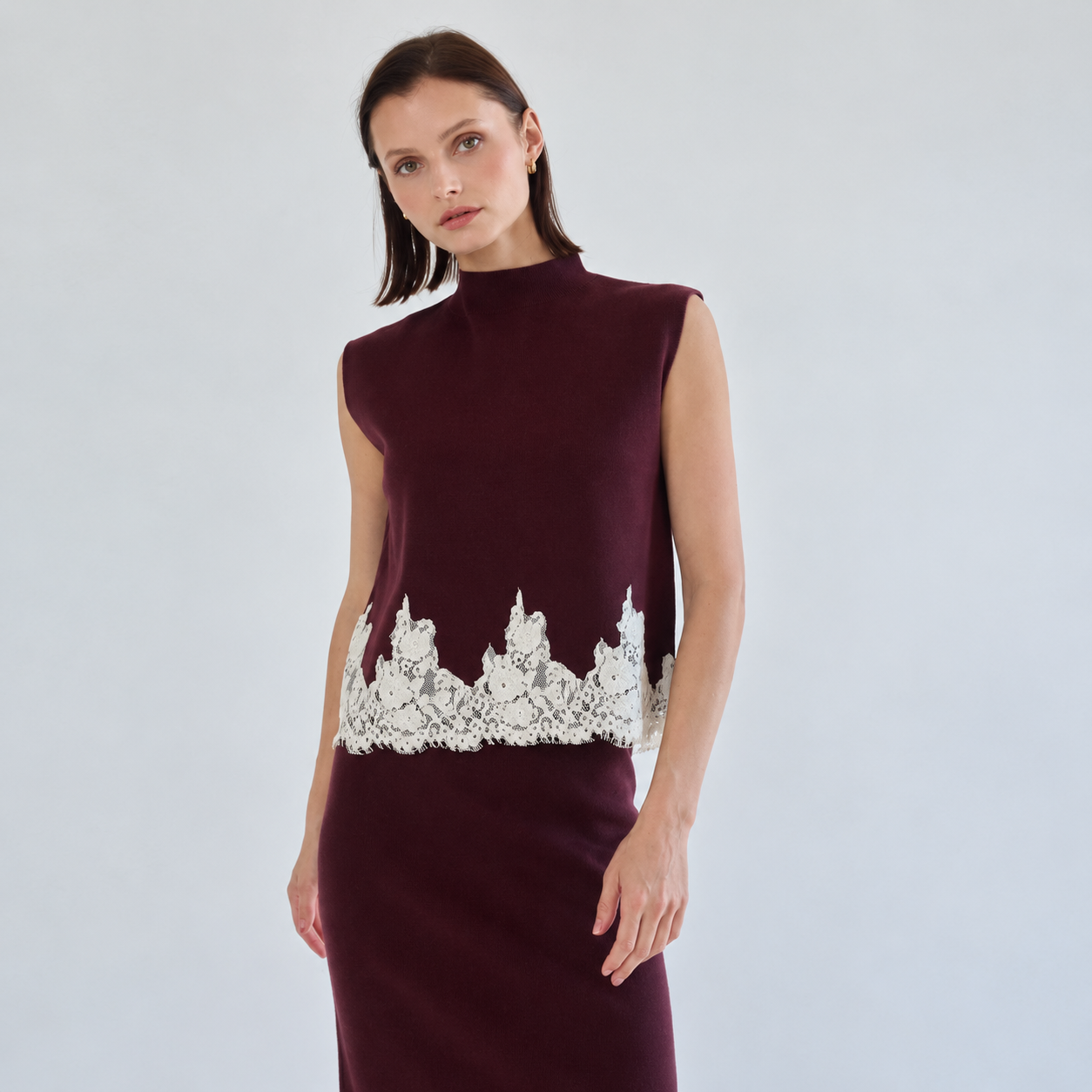 Sleeveless mock-neck burgundy knit top with ivory scalloped floral lace