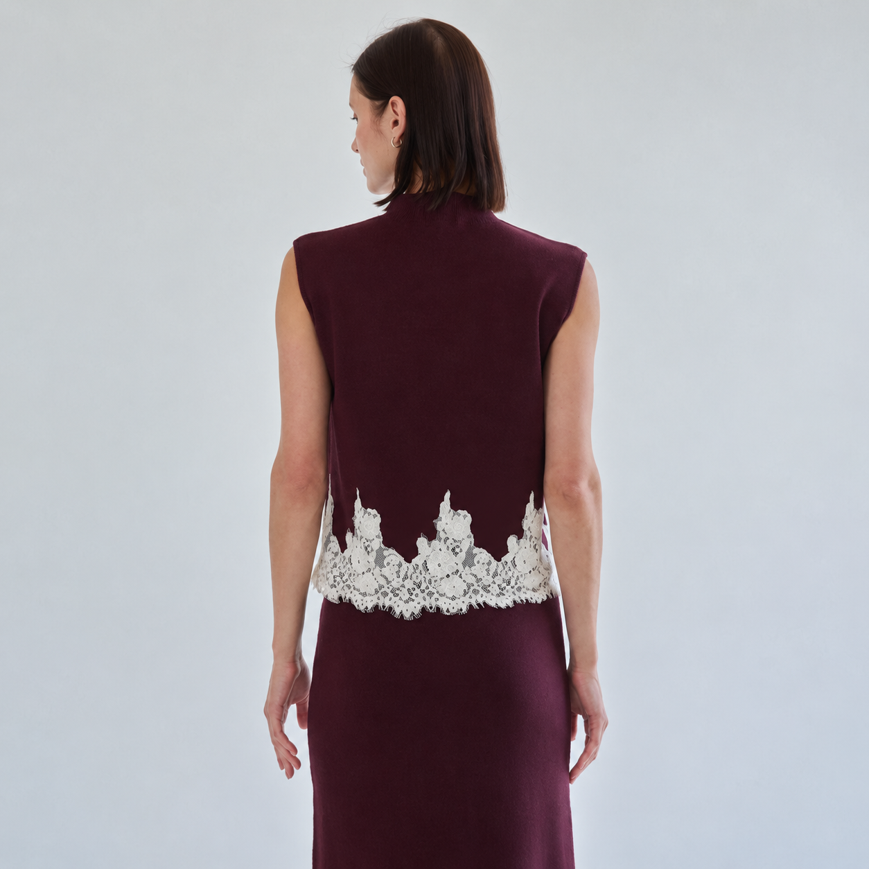 Back of burgundy knit top showing ivory lace hem