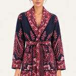 Nadège navy paisley jacquard belted cardigan with shawl collar and patch pockets on a model, ivory studio background