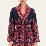Nadège navy paisley jacquard belted cardigan with shawl collar and patch pockets on a model, ivory studio background