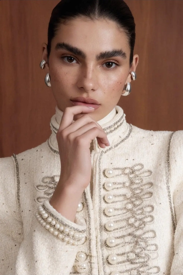 Regent Pearl-Embellished Bouclé Jacket — Close-up of the ivory bouclé jacket with faux-pearl embellishments and braided trim