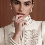 Regent Pearl-Embellished Bouclé Jacket — Close-up of the ivory bouclé jacket with faux-pearl embellishments and braided trim