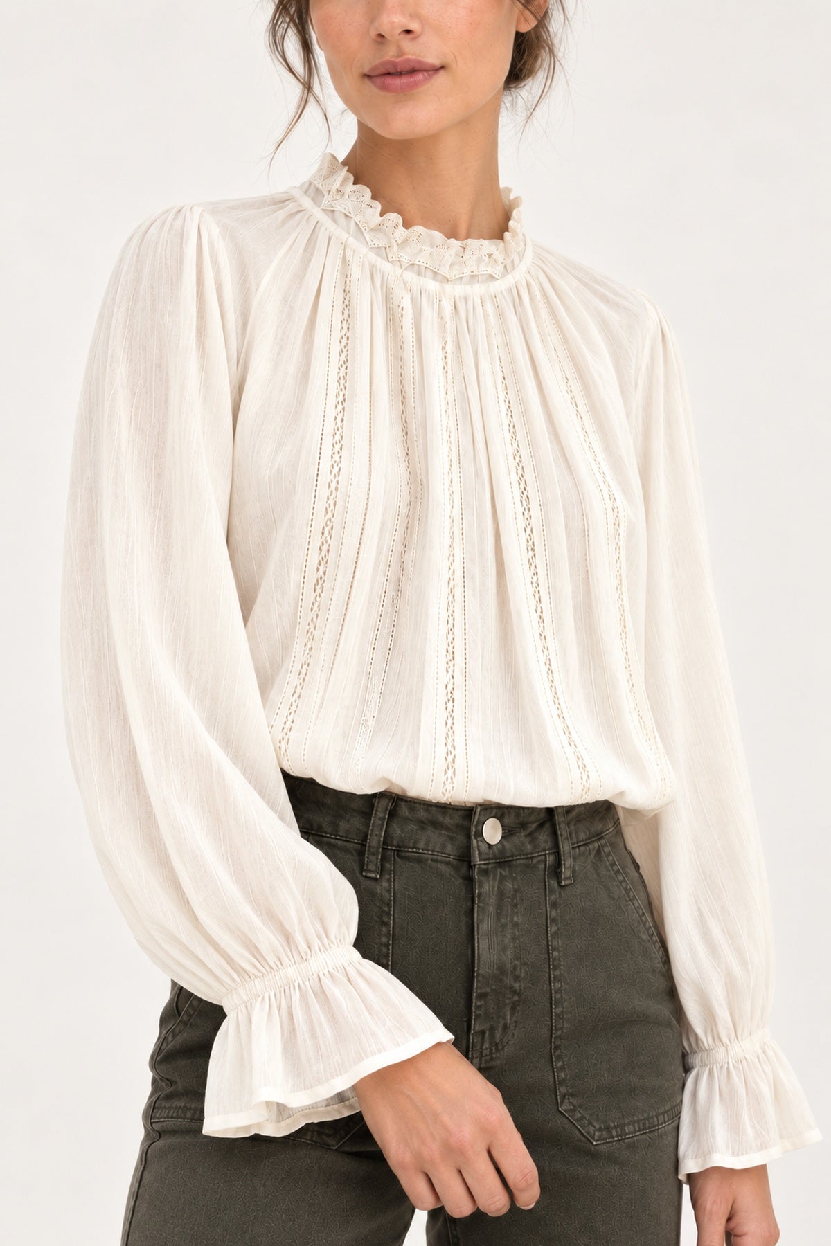Sabine écru lace-trim blouse, detail view showing ruffled collar and fluted cuffs on a model against an ivory background