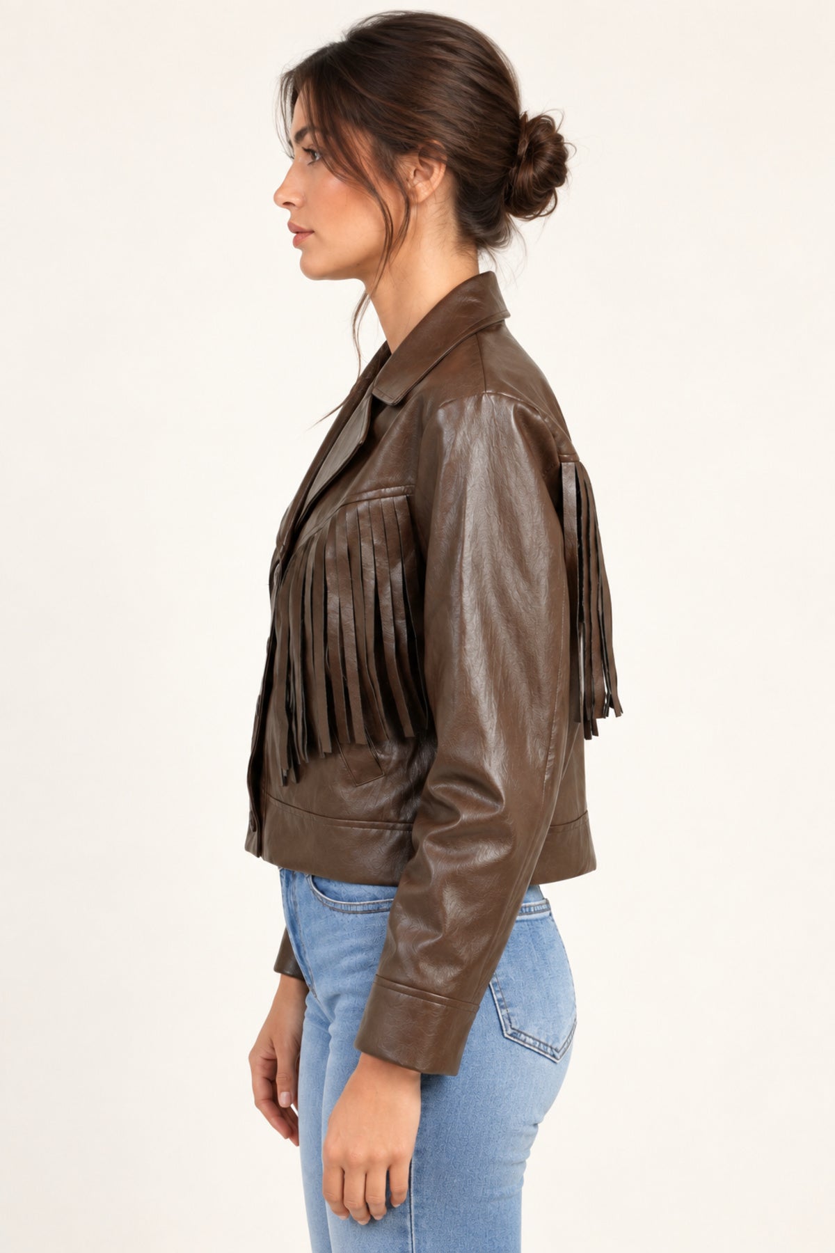 Sidonie fringe faux-leather jacket in Coffee, side view on an ivory studio backdrop